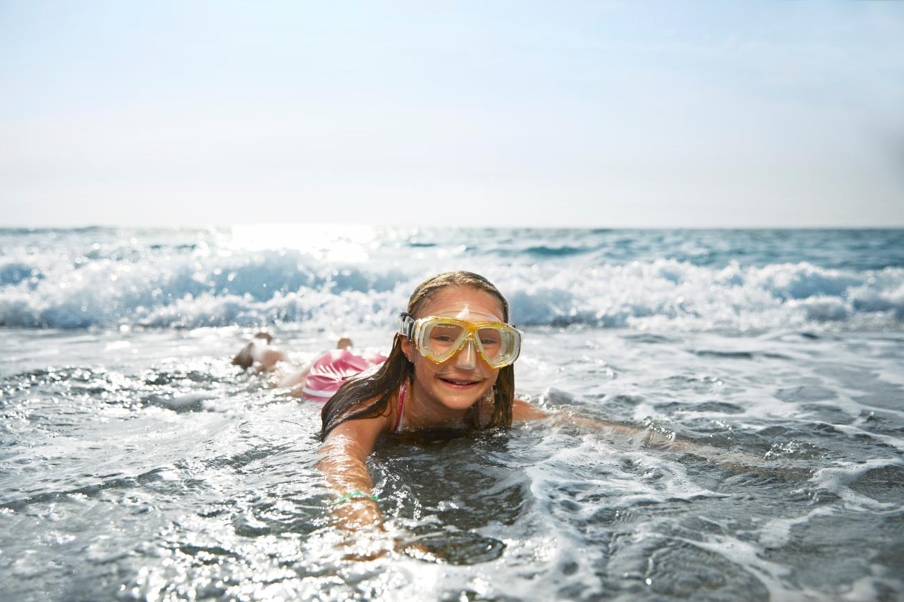 Kind spielt im Meer