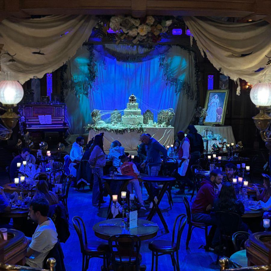Sfeervolle eetzaal met blauw licht en versiering geïnspireerd op de bruiloft van Phantom  Manor